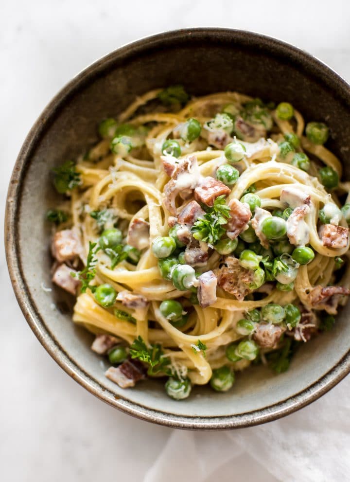 Pasta with pancetta, peas, a creamy garlic sauce, and plenty of fresh parmesan makes an easy and tasty dinner!