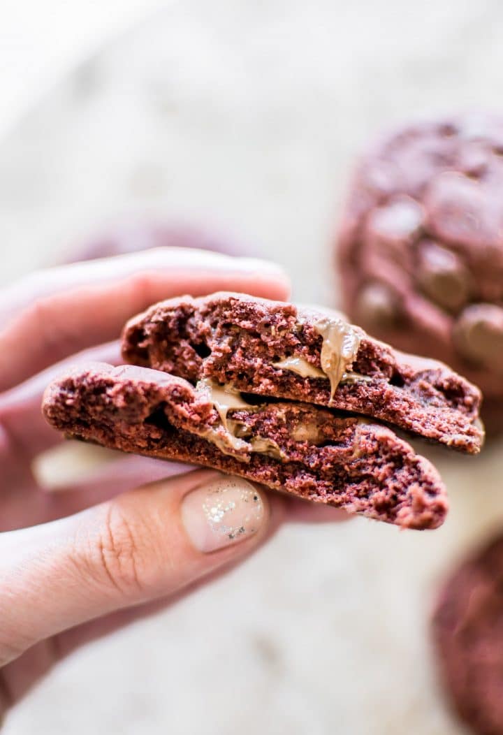 a female hand holding a red velvet cake mix cookie
