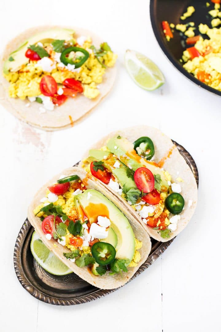 scrambled tofu breakfast tacos on a plate with lime wedge