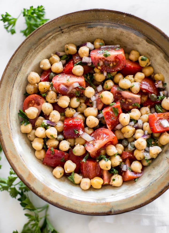 This easy vegan tomato chickpea salad recipe is healthy, delicious, and perfect for summer. You'll love the simple lemon vinaigrette. This cold chickpea salad is great for meal prep. 
