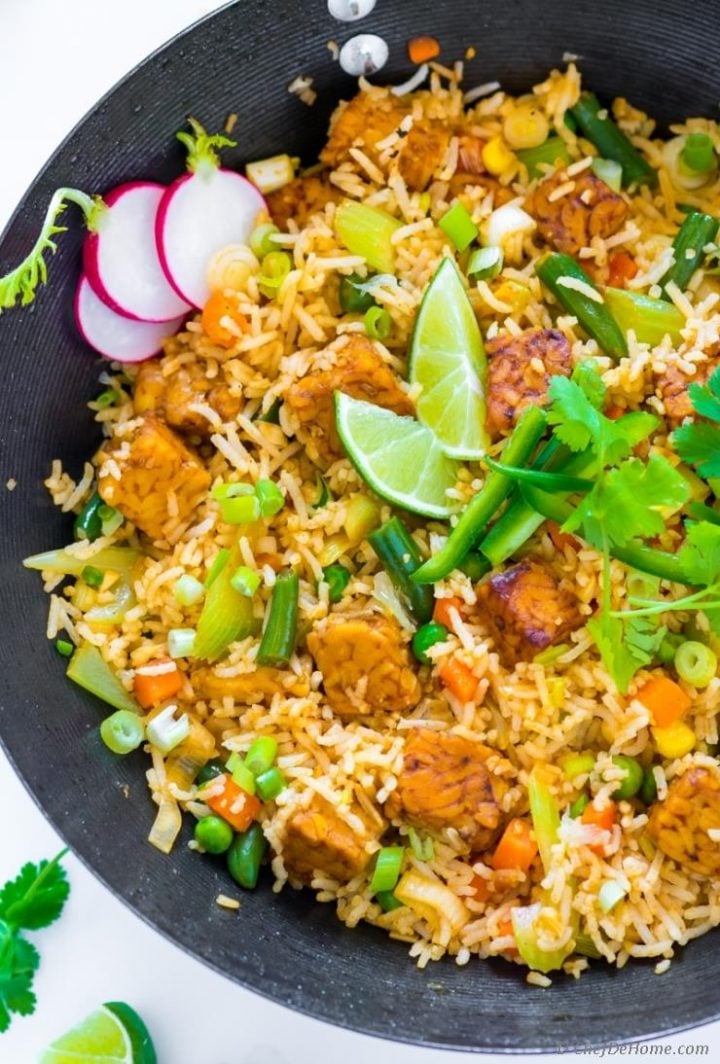 vegan fried rice with tempeh in a bowl with lime garnish