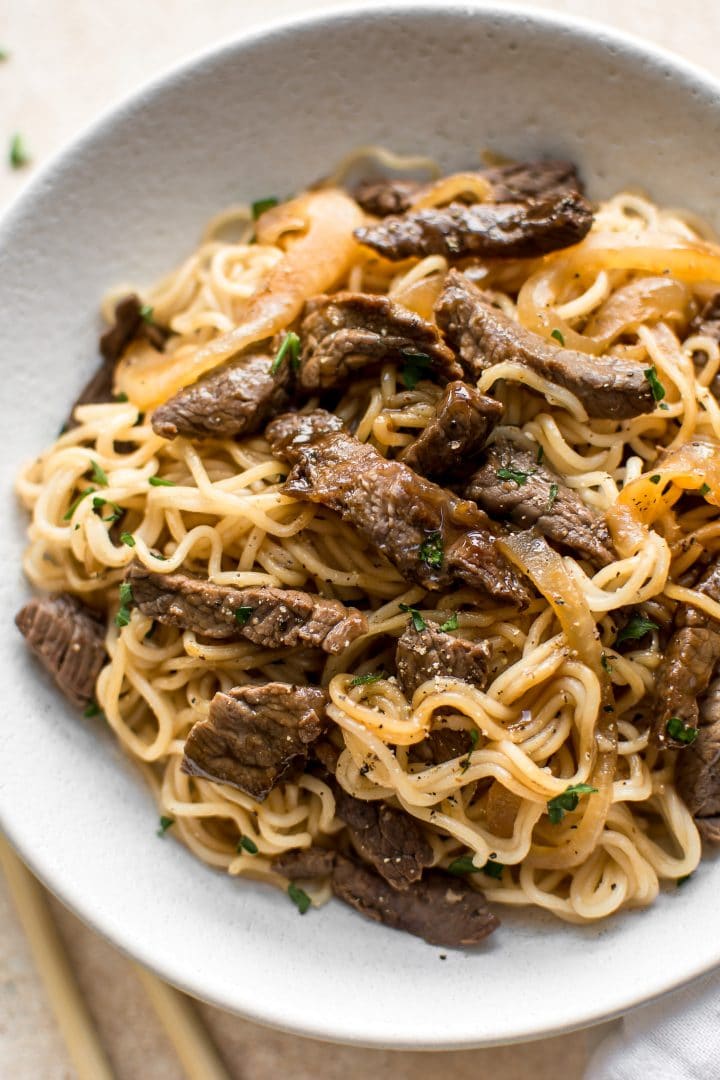 close-up of Asian beef and ramen noodles on a white plate