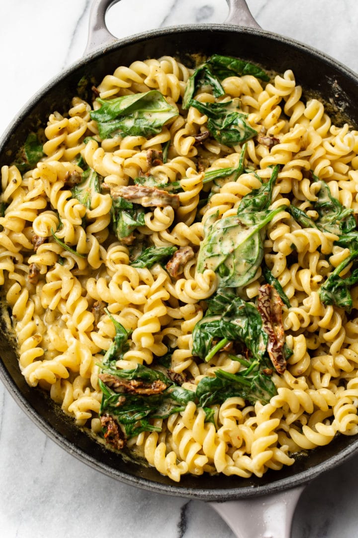 close-up of creamy chicken pesto pasta in a skillet