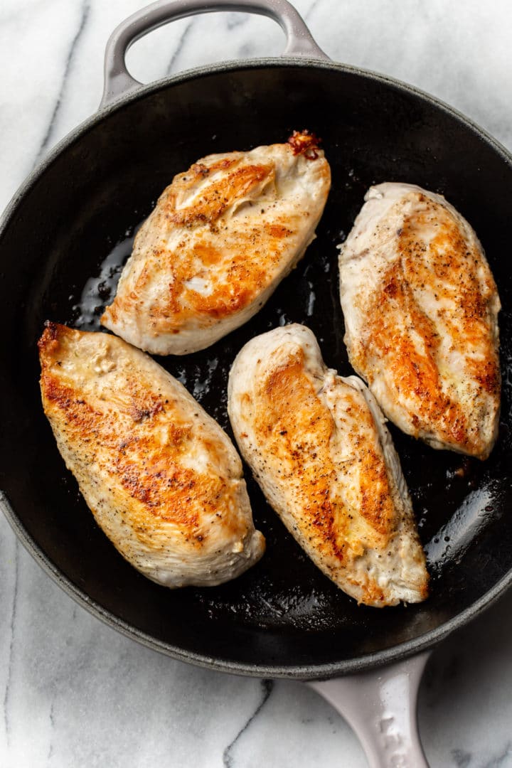 seared chicken in a skillet for chicken pesto pasta