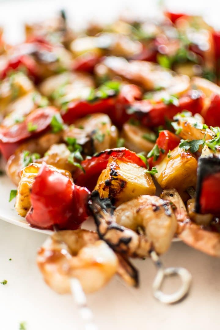 close-up of several grilled shrimp kabobs with a honey glaze on a plate