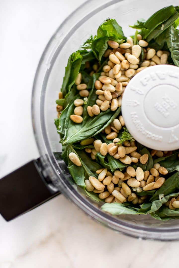 basil and pine nuts in a food processor