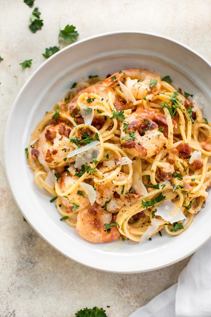 creamy shrimp and bacon pasta in a white bowl