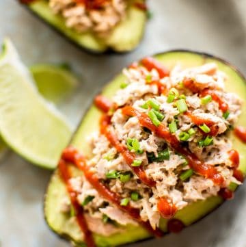 This spicy tuna stuffed avocado is healthy, fast, and delicious. This low-carb keto recipe is ready in only 10 minutes! It's super flavorful with sriracha, lime, mayo, mustard, and chives! An easy lunch idea.