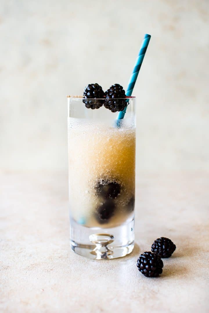 a tall clear glass of frozen riesling (friesling) and a blue paper straw