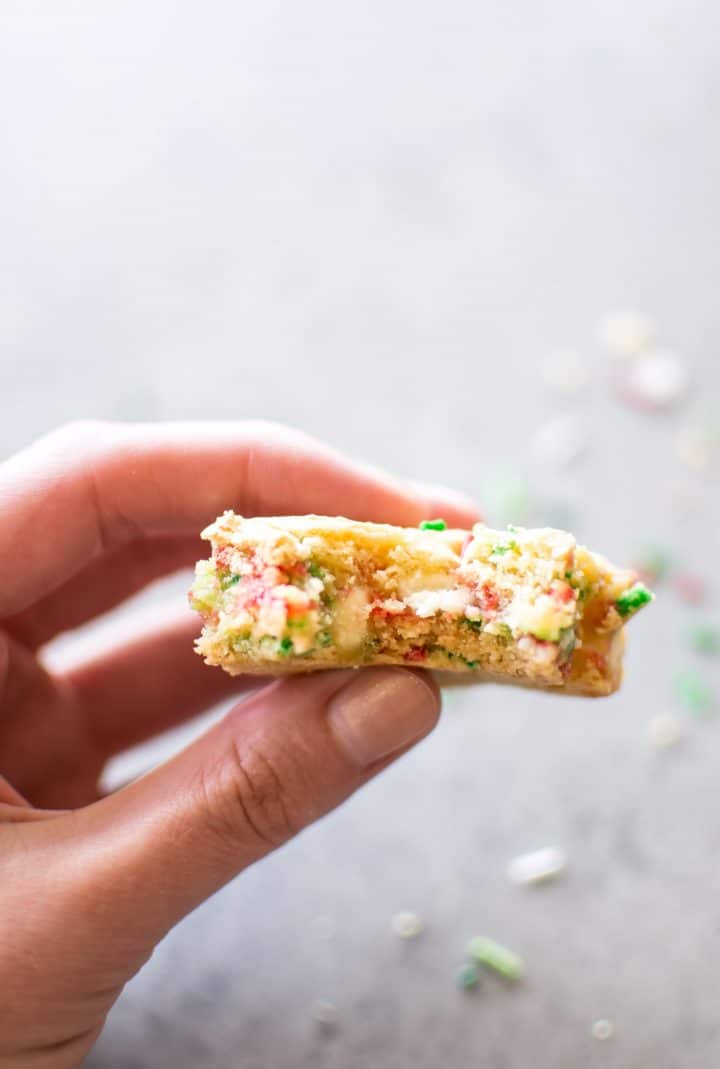 female hand holding a Christmas cake batter blondie