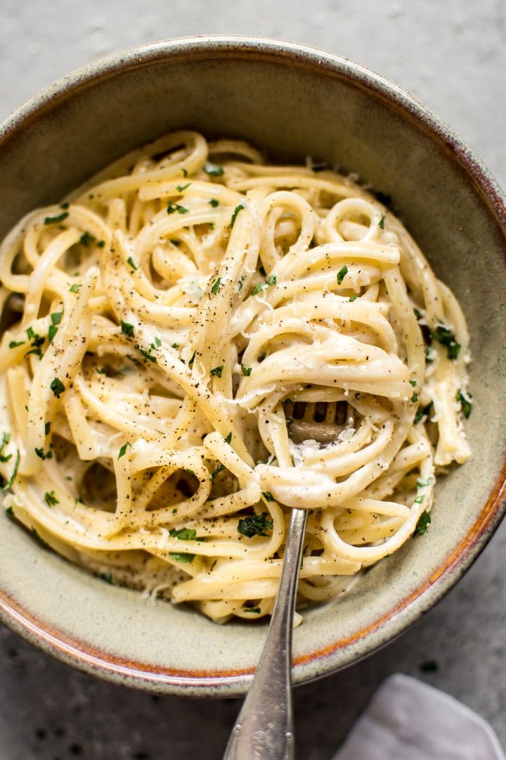 close-up of creamy garlic pasta on fork