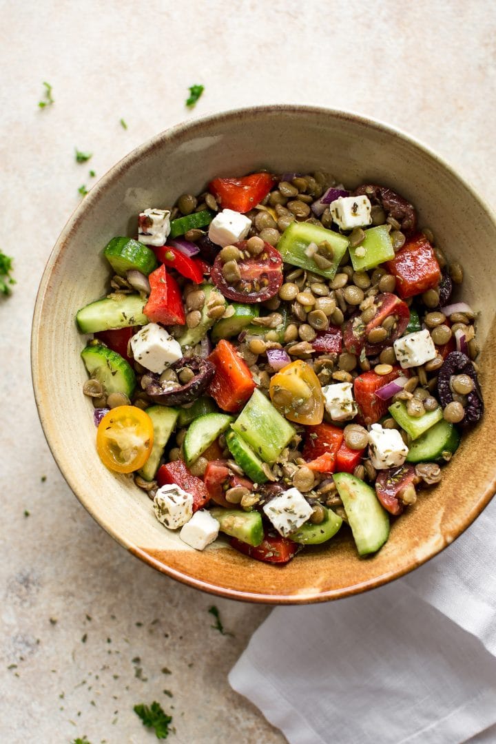 mediterranean lentil salad with cucumbers and tomatoes in an earthenware bowl