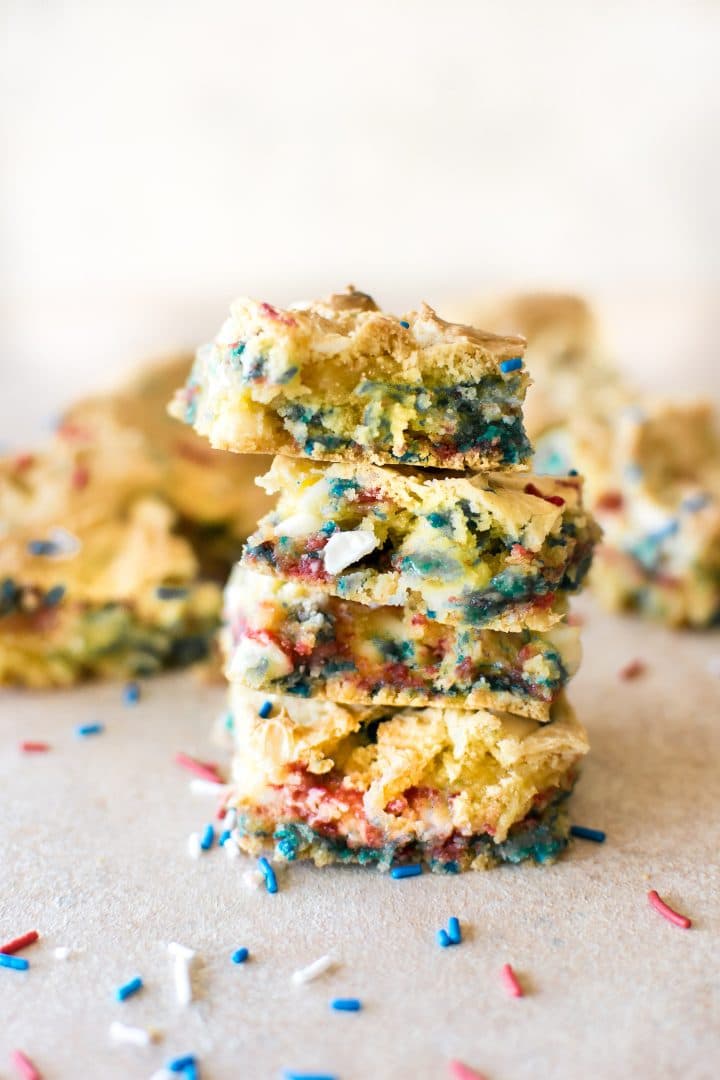 a stack of red, white, and blue patriotic cookie bars with a bite in one