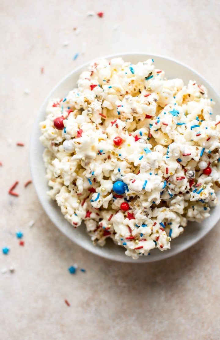 fourth of july popcorn with patriotic colored sprinkles in a white bowl