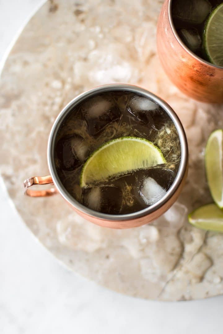 copper mug with rhubarb Moscow mule beside lime wedges