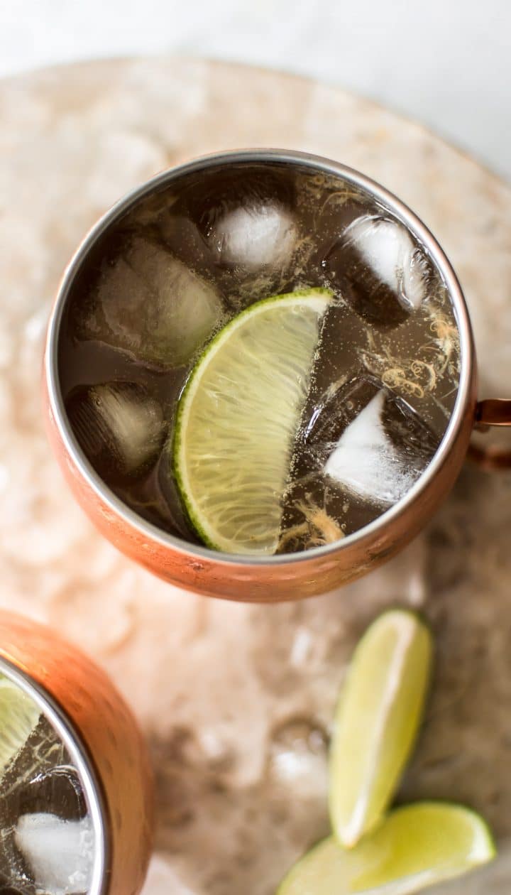 close-up of rhubarb Moscow mule cocktail in a metal mug with ice and lime wedge