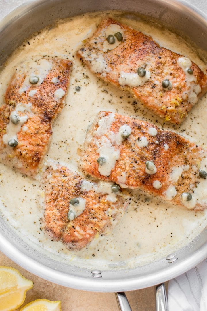 close-up of creamy lemon salmon piccata in a skillet