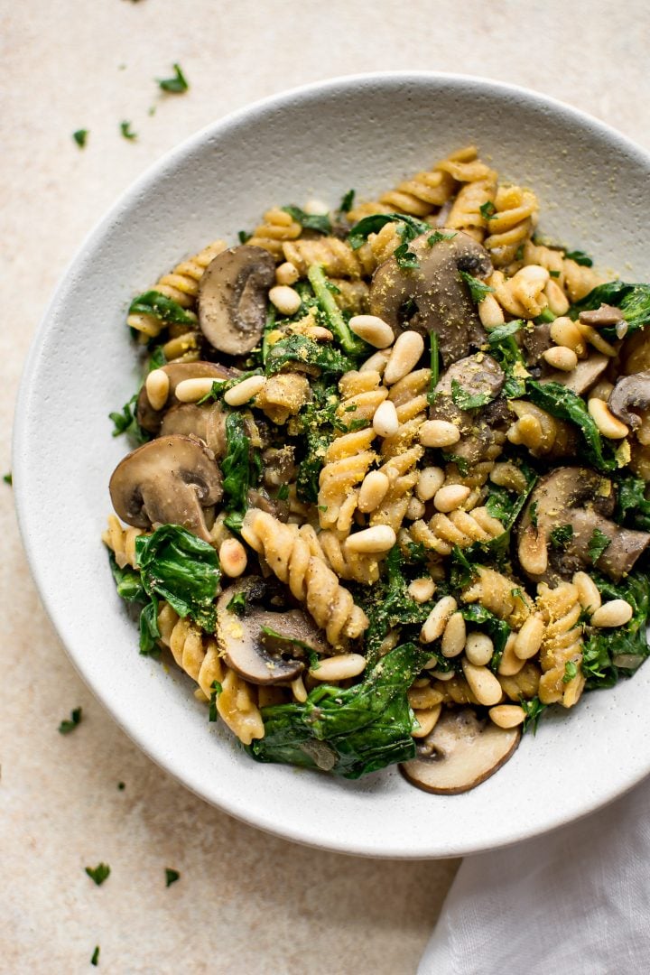 vegan spinach mushroom pasta on a white plate