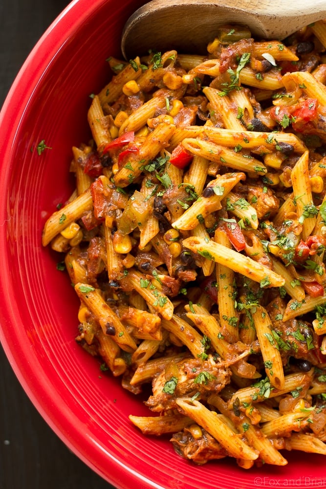 chicken taco pasta close-up in a red bowl with wooden cooking spoon