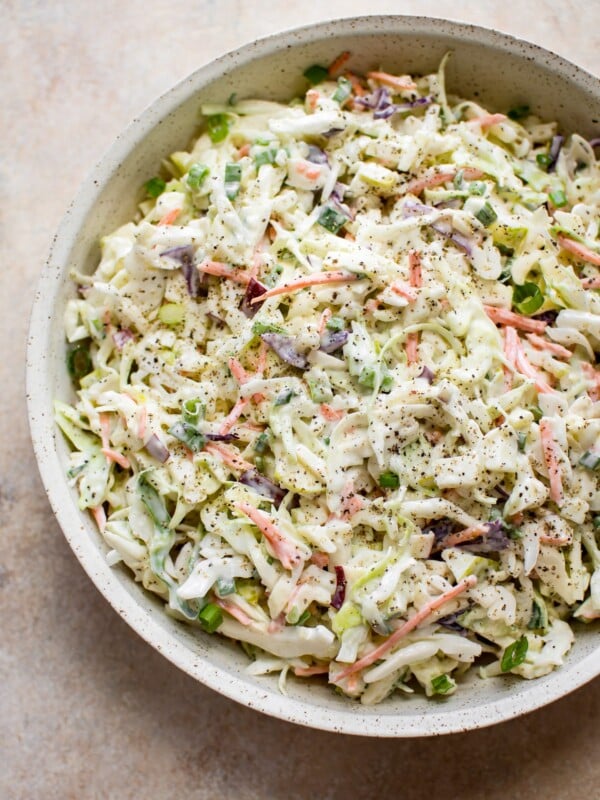 This simple apple slaw has cabbage, carrots, scallions, red and granny smith apples, and a tangy and sweet creamy dressing. This coleslaw recipe is great for pulled pork sandwiches!