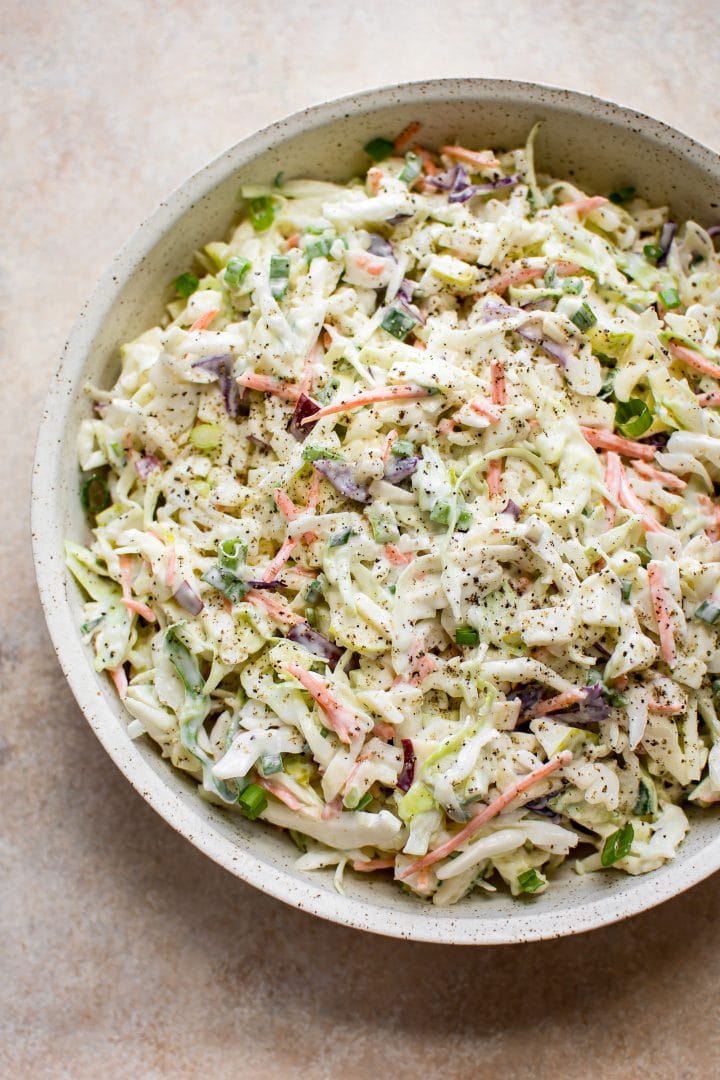 simple apple, cabbage, and carrot slaw in a beige bowl