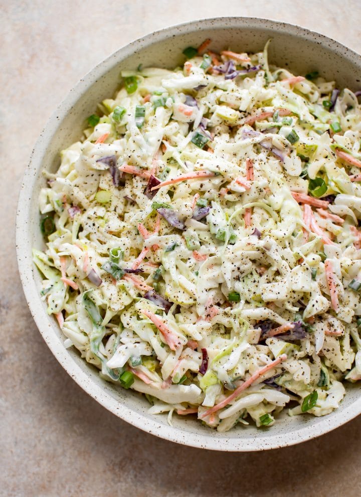 This simple apple slaw has cabbage, carrots, scallions, red and granny smith apples, and a tangy and sweet creamy dressing. This coleslaw recipe is great for pulled pork sandwiches!