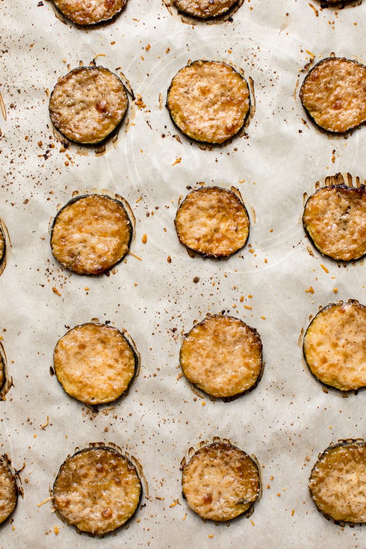 close-up of low carb zucchini rounds with parmesan on a baking sheet