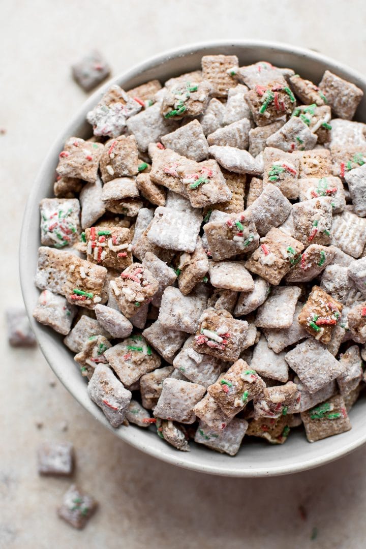 white bowl of Christmas puppy chow with sprinkles and peppermint