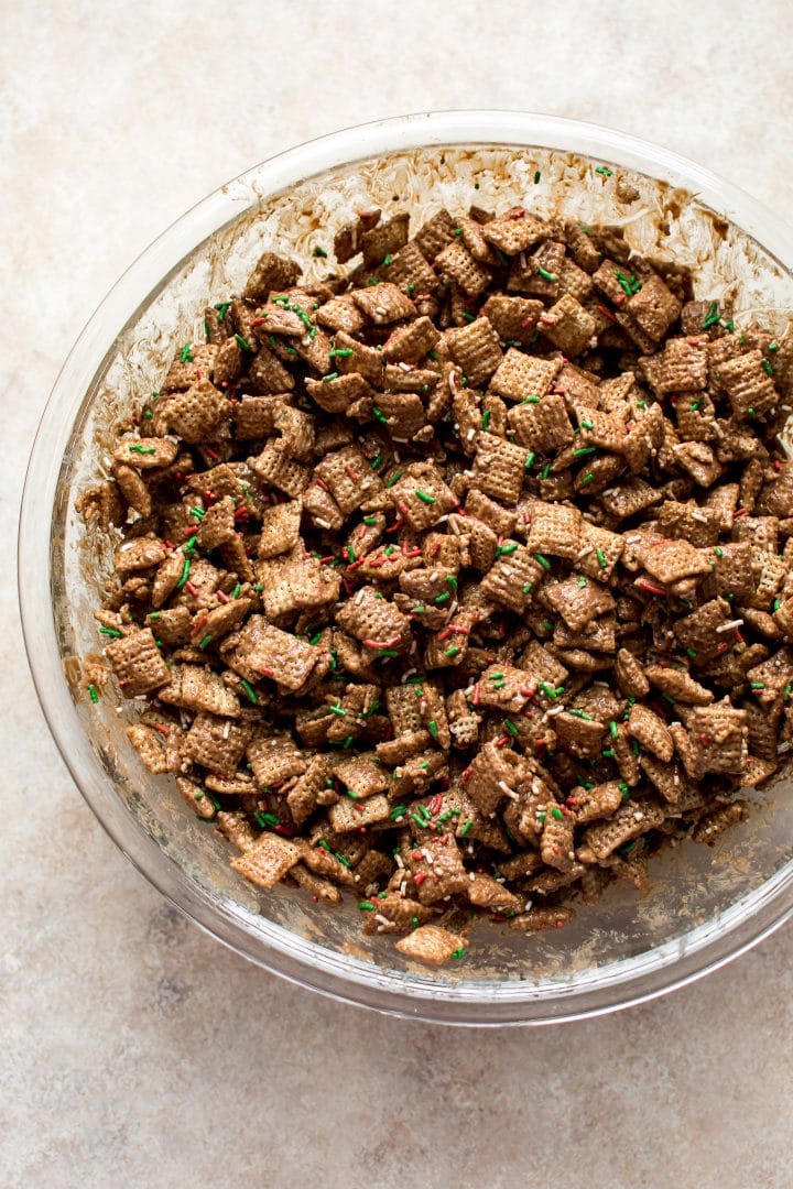 glass mixing bowl with ingredients for holiday puppy chow