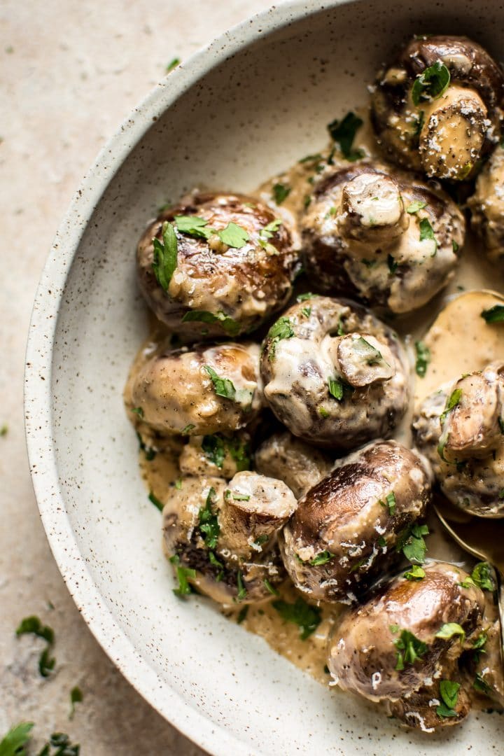 creamy garlic mushrooms in a beige bowl