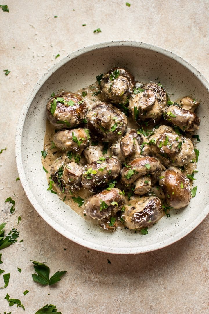 creamy garlic mushrooms topped with parsley in a bowl