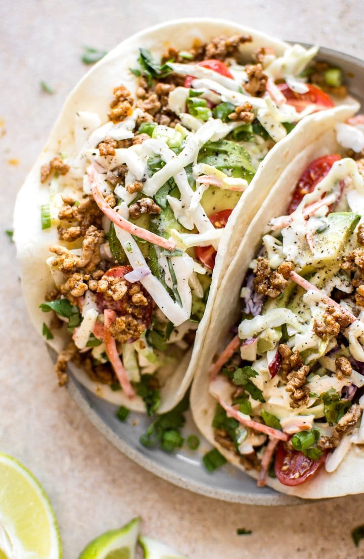 close-up of two ground pork tacos with homemade apple slaw on a plate