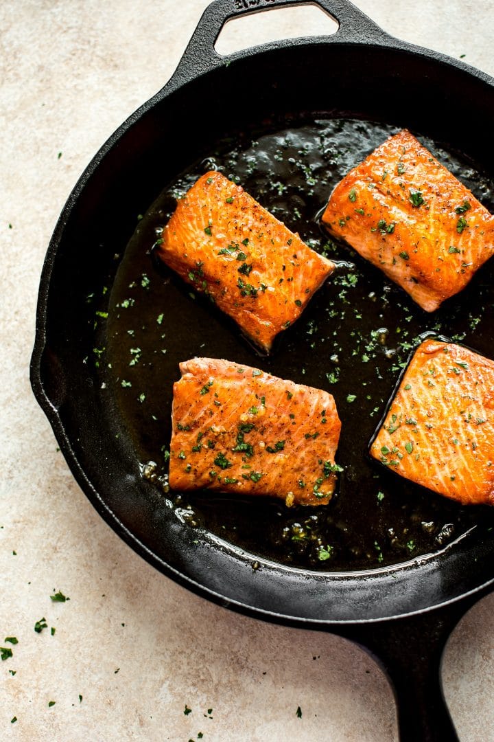 honey garlic glazed salmon pieces in a cast iron pan