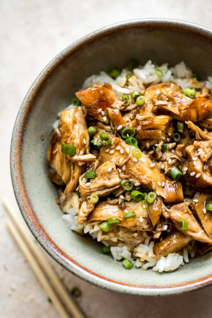 close-up of Instant Pot easy teriyaki chicken in a bowl beside chopsticks