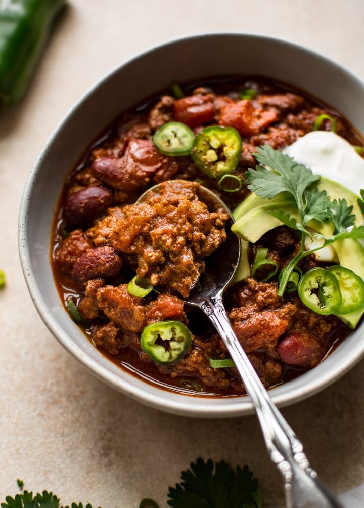 ground beef chili in a white bowl with a spoon
