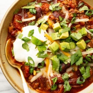 a bowl of quick chili with toppings and a spoon