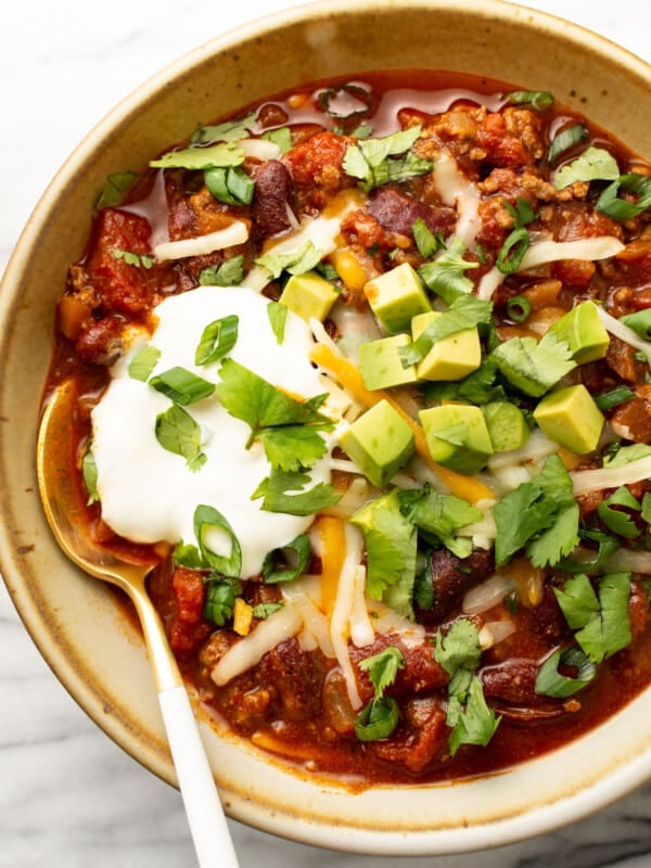 a bowl of quick chili with toppings and a spoon