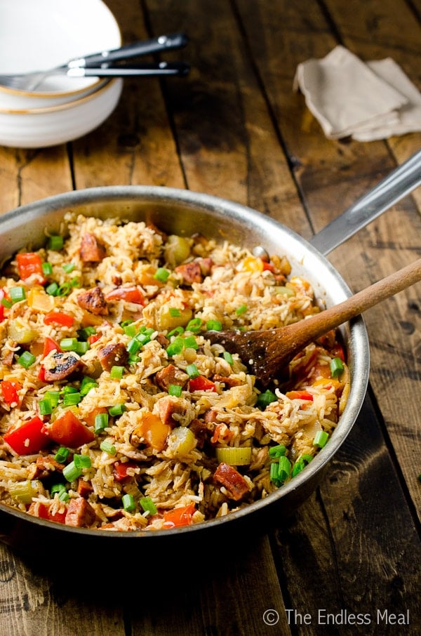chicken and chorizo jambalaya in a skillet with a wooden spoon