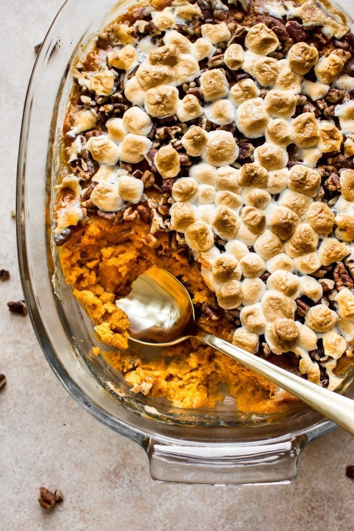 sweet potato casserole in a glass baking dish with serving spoon