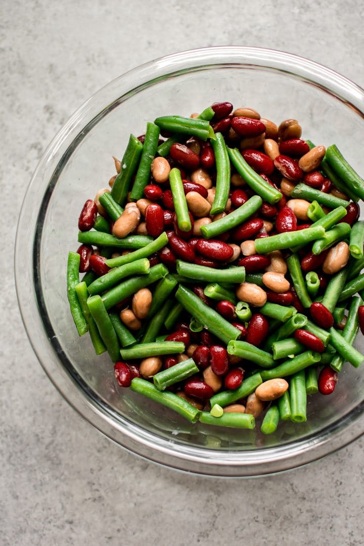 glass mixing bowl with ingredients for healthy three bean salad