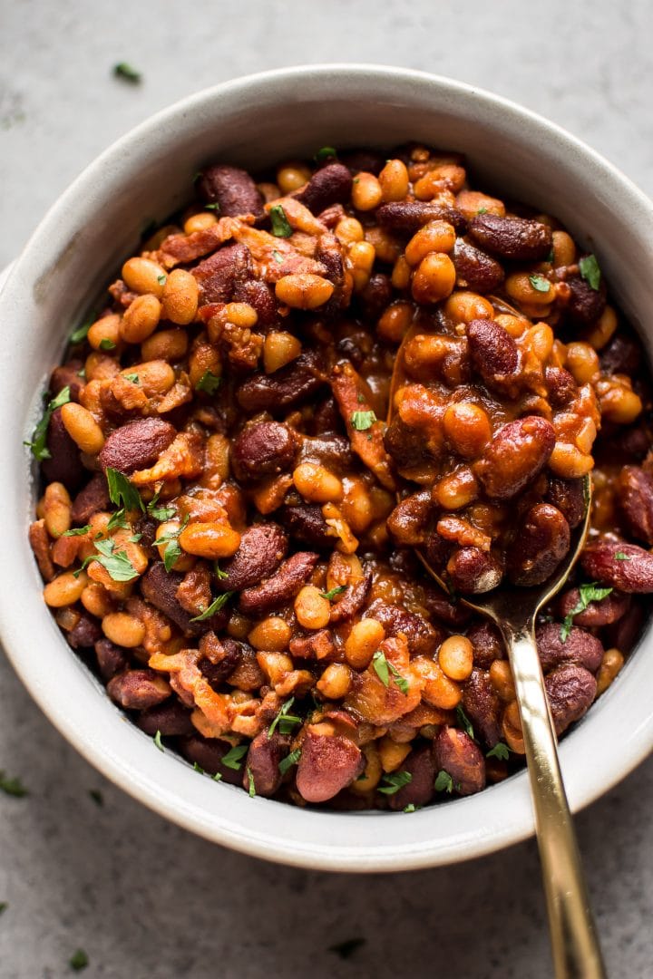 close-up of easy homemade baked beans with bacon in a bowl with a spoon