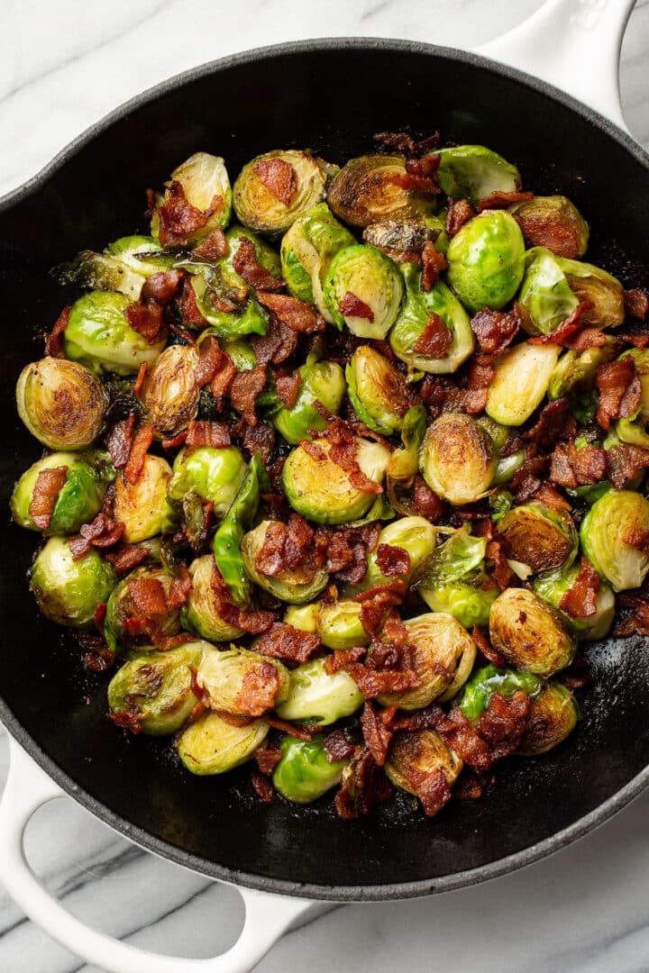 a cast iron skillet with brussels sprouts and bacon