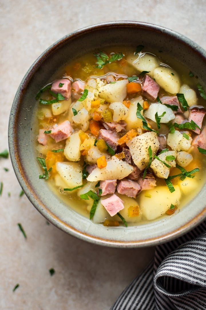 easy Crockpot ham and potato soup in a bowl beside a cloth napkin
