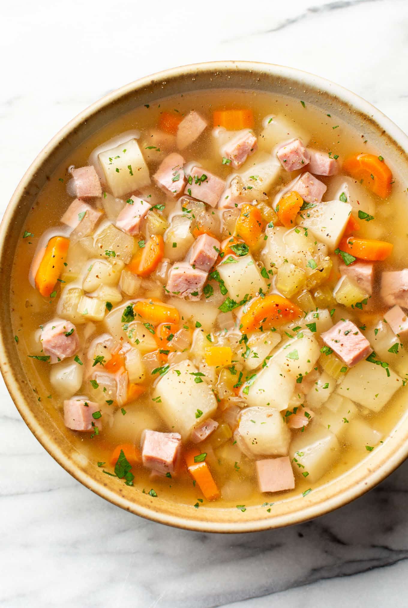 Slow cooker ham and potato soup in a bowl with a creamy broth