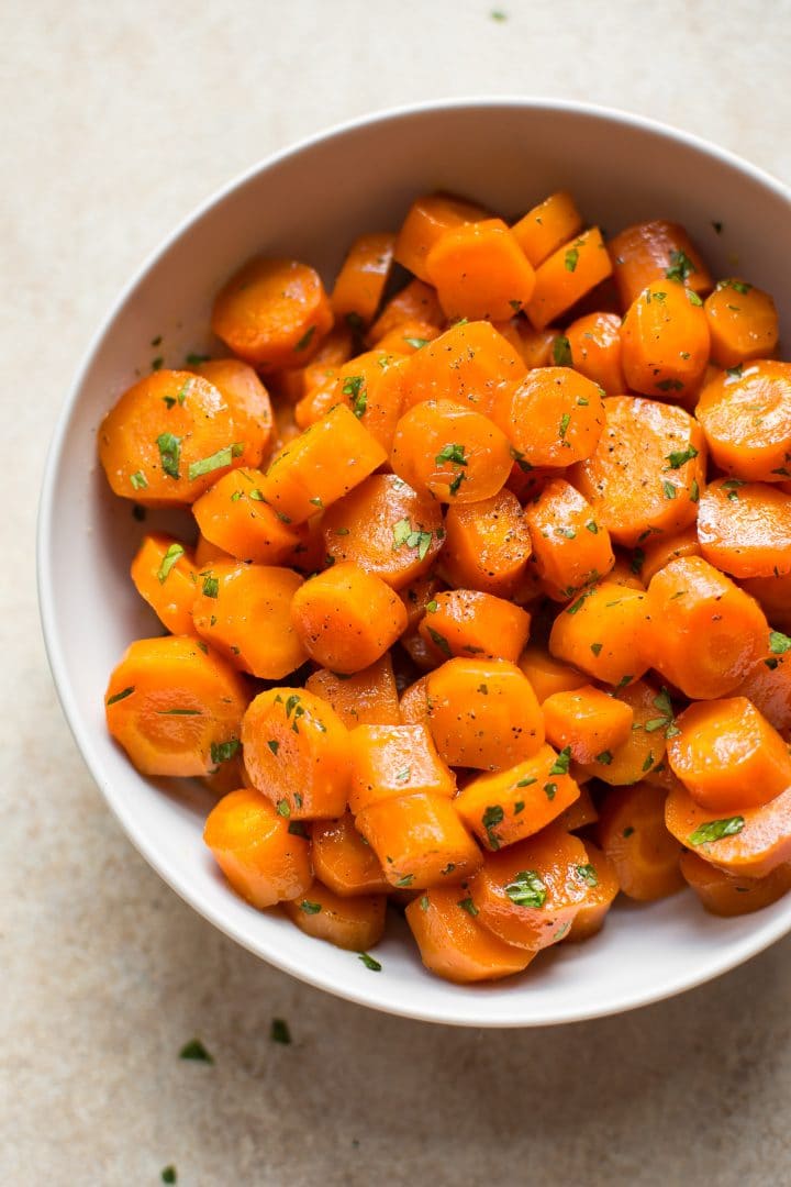 close-up of honey glazed oven-roasted carrots in a white bowl