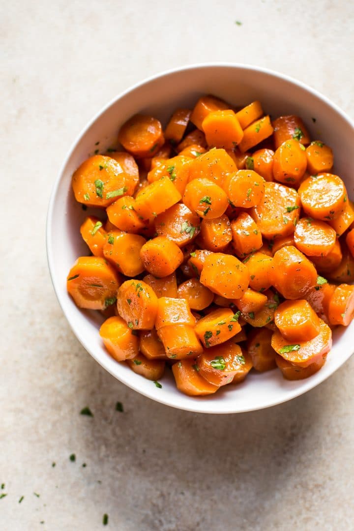 easy honey roasted carrots in a bowl topped with parsley