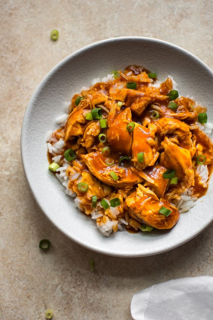 Instant Pot honey sriracha chicken served over rice on a white plate