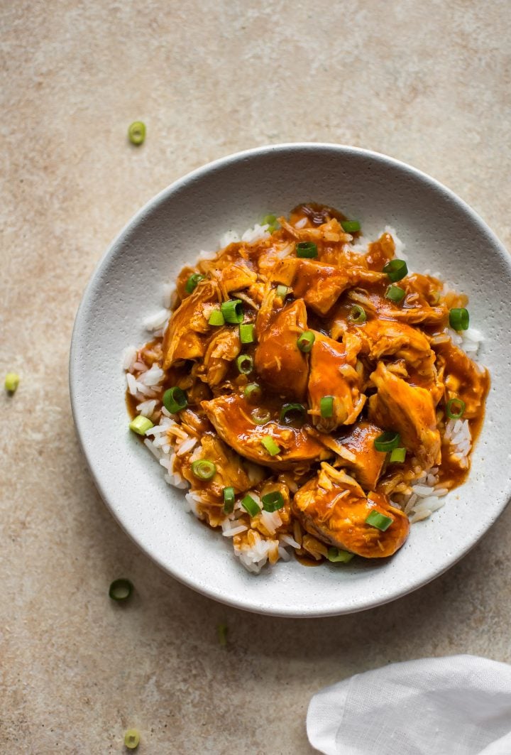 sweet and spicy Instant Pot honey sriracha chicken in a white bowl