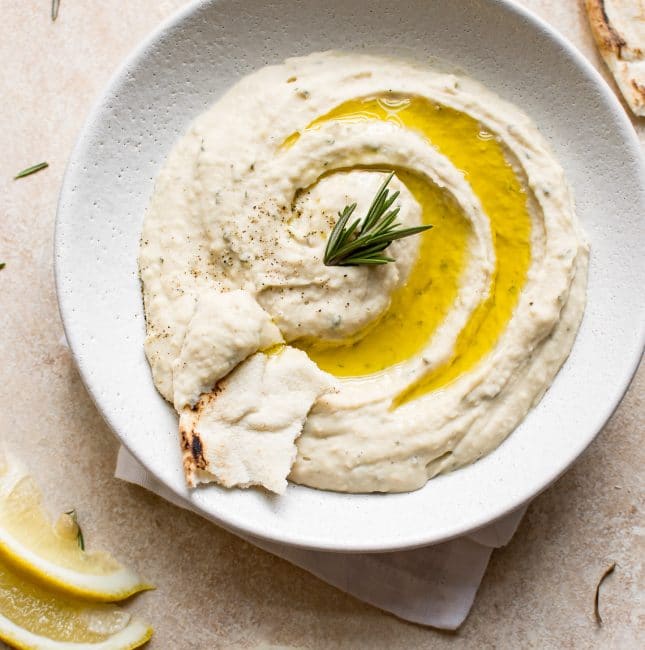 This easy vegan white bean dip is infused with rosemary, lemon juice, garlic, and good olive oil. It's a delicious and healthy dip that's perfect for girls' night or game day.
