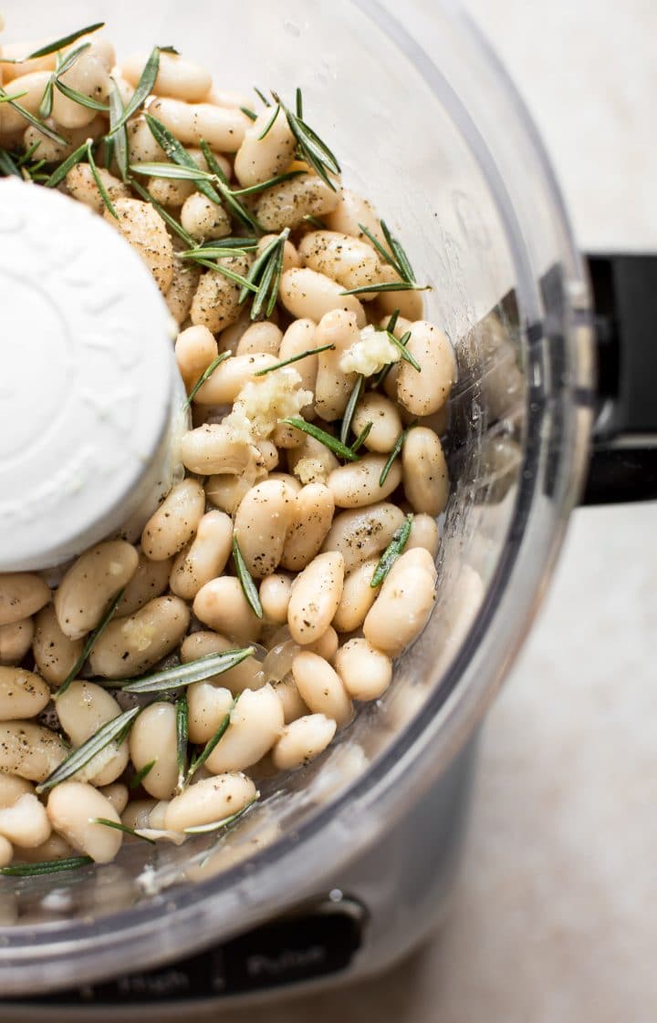 ingredients for rosemary and white bean dip in a food processor